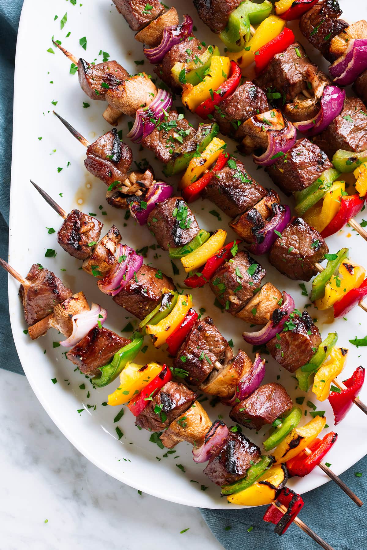 Grilled Steak Kebabs on an oval white platter.