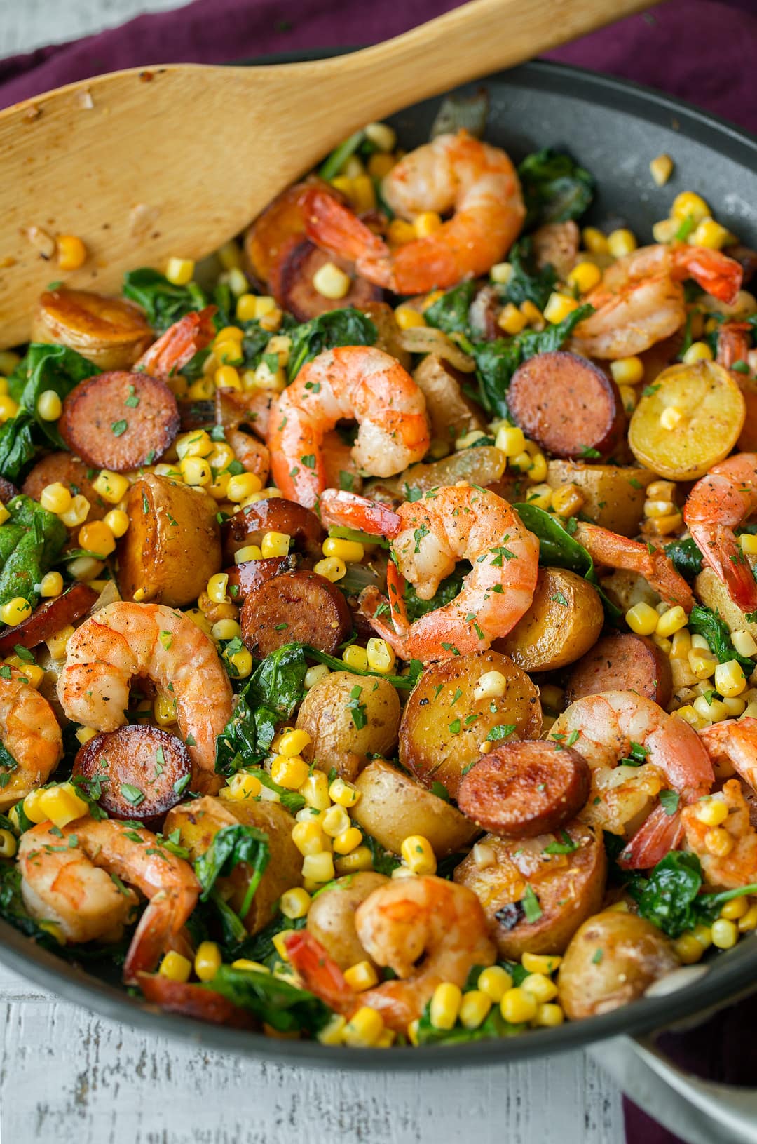 Shrimp Boil that includes shrimp, potatoes, corn, sausage, old bay seasoning, spinach and lemon