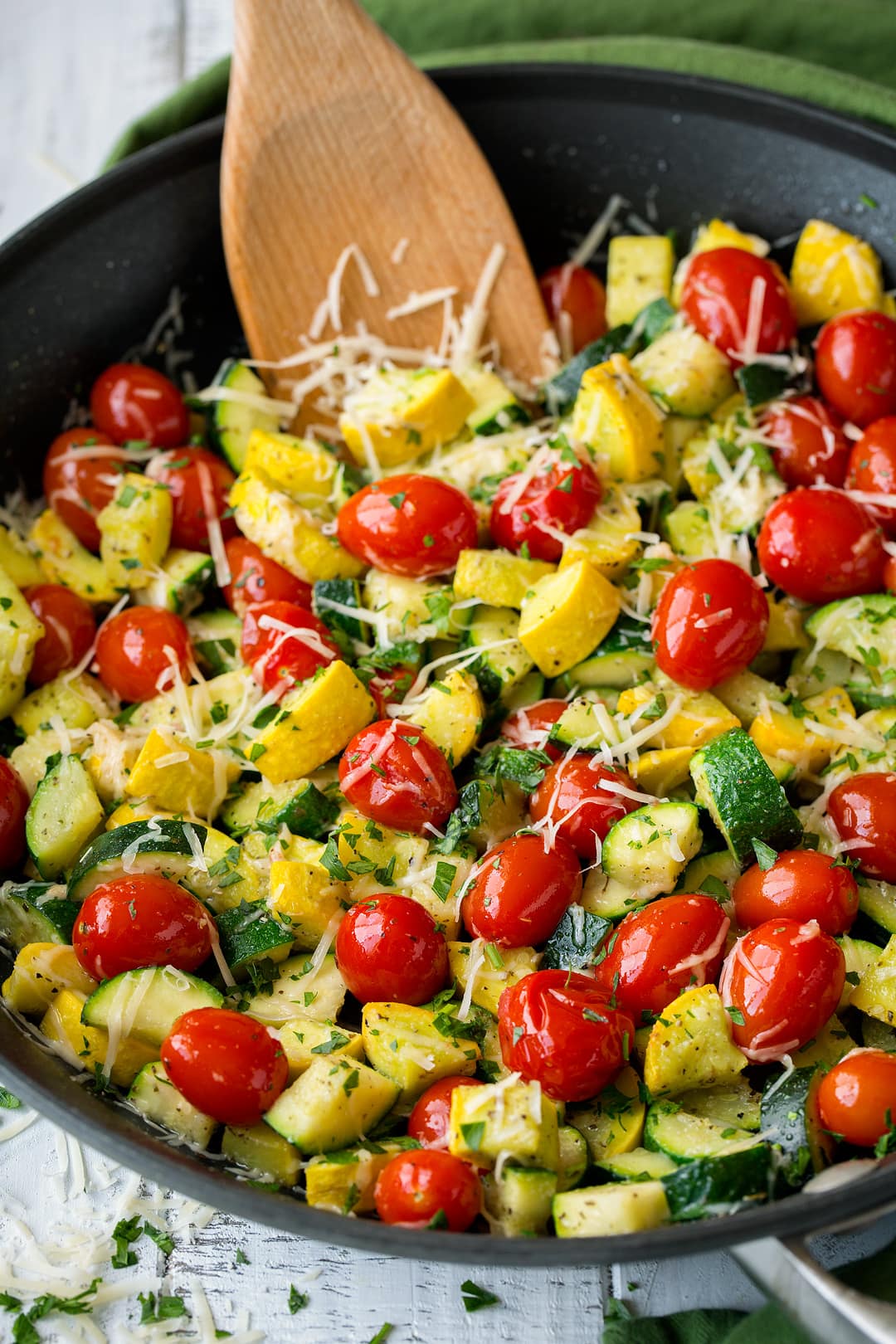 sauteed zucchini and squash with tomatoes in a large black skillet.