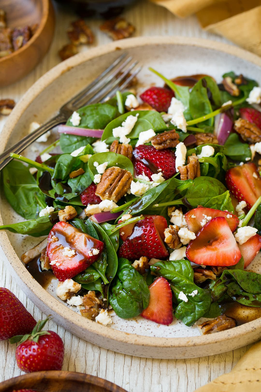 A Strawberry Spinach Salad in a bowl with a fork