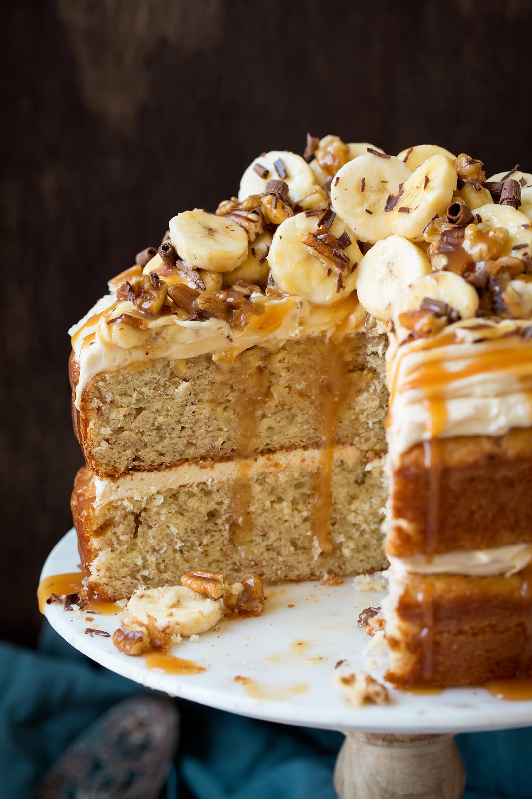 Close up image of sliced banana cake sitting on marble cake stand.