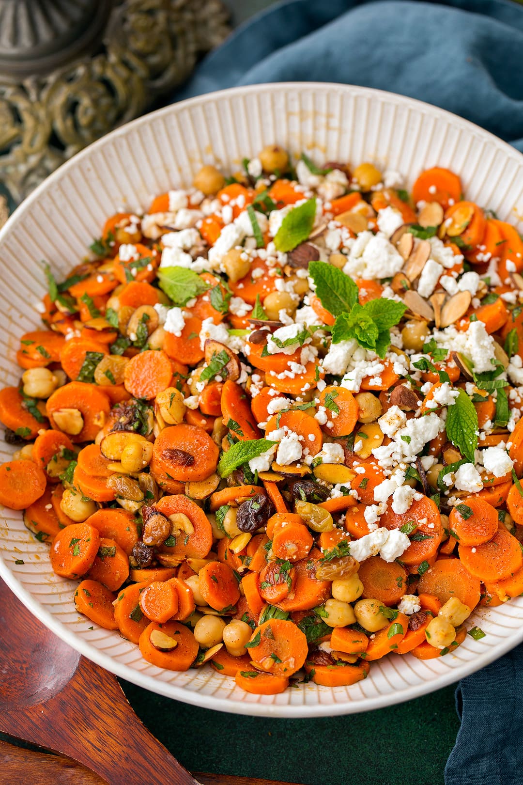 Carrot Salad with chick peas, feta, almonds and raisins. Shown here in a large white shallow bowl.