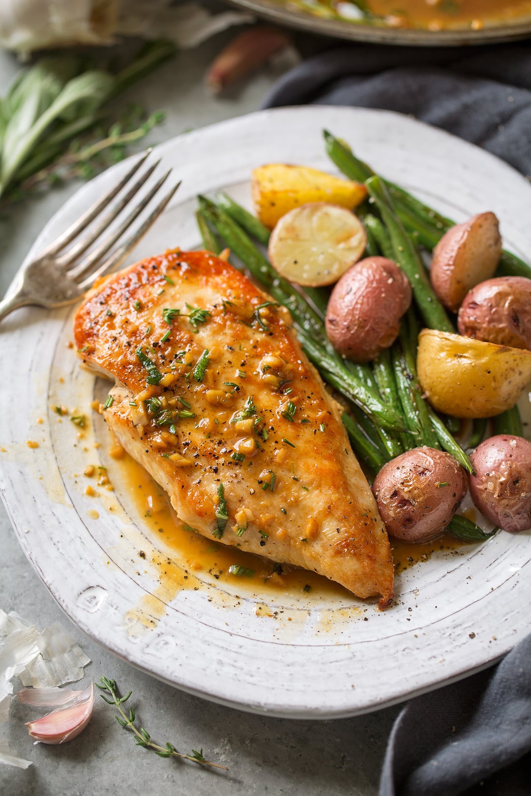 Skillet Chicken with Garlic Herb Butter Sauce on a plate with roast vegetables