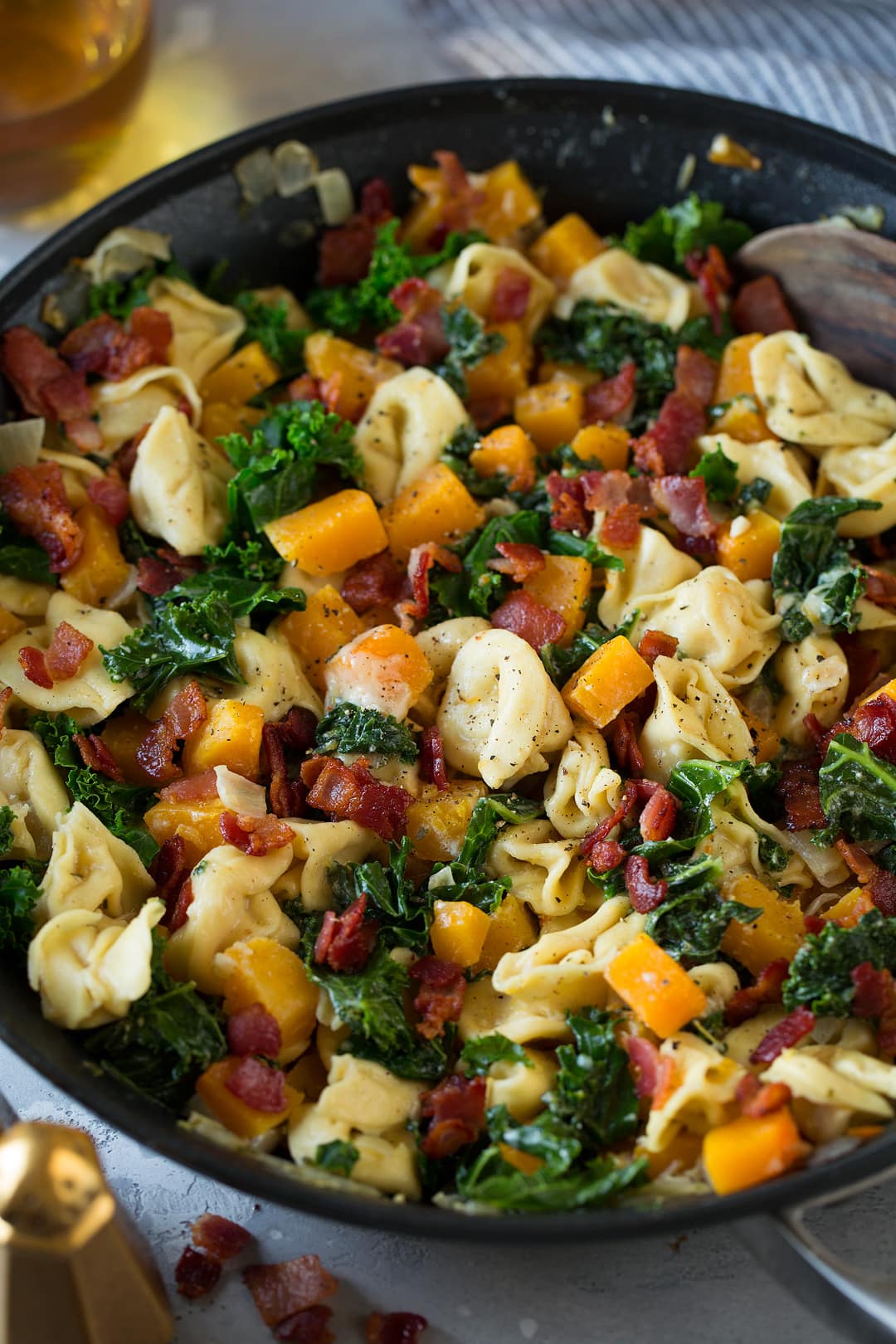 Tortellini with Butternut Squash Kale and Bacon in a large skillet
