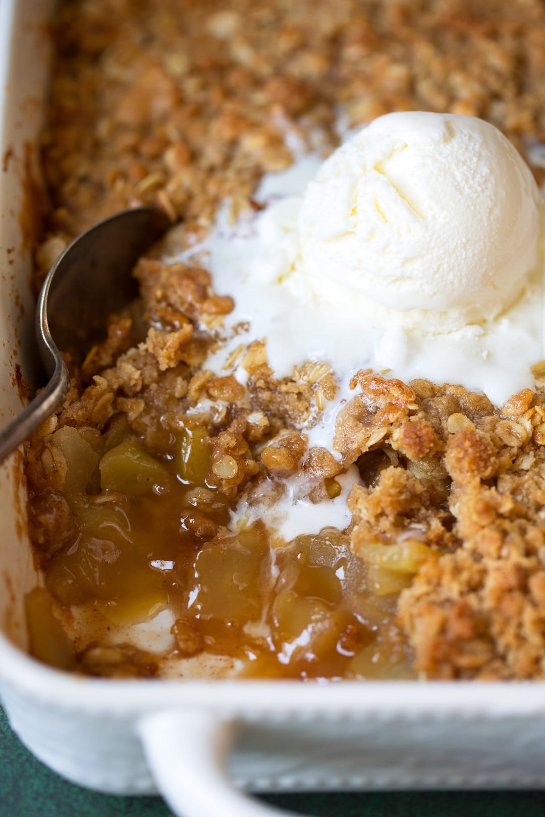 Pan of Apple Crisp with a scoop of vanilla ice cream.