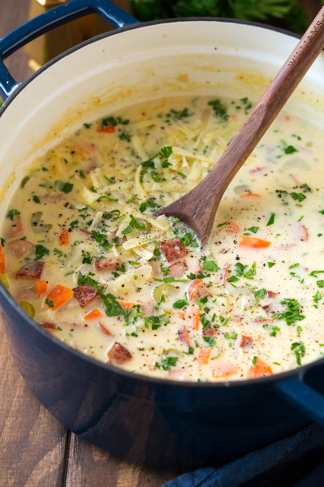 Potato Soup with Sausage and White Cheddar in a large navy blue pot