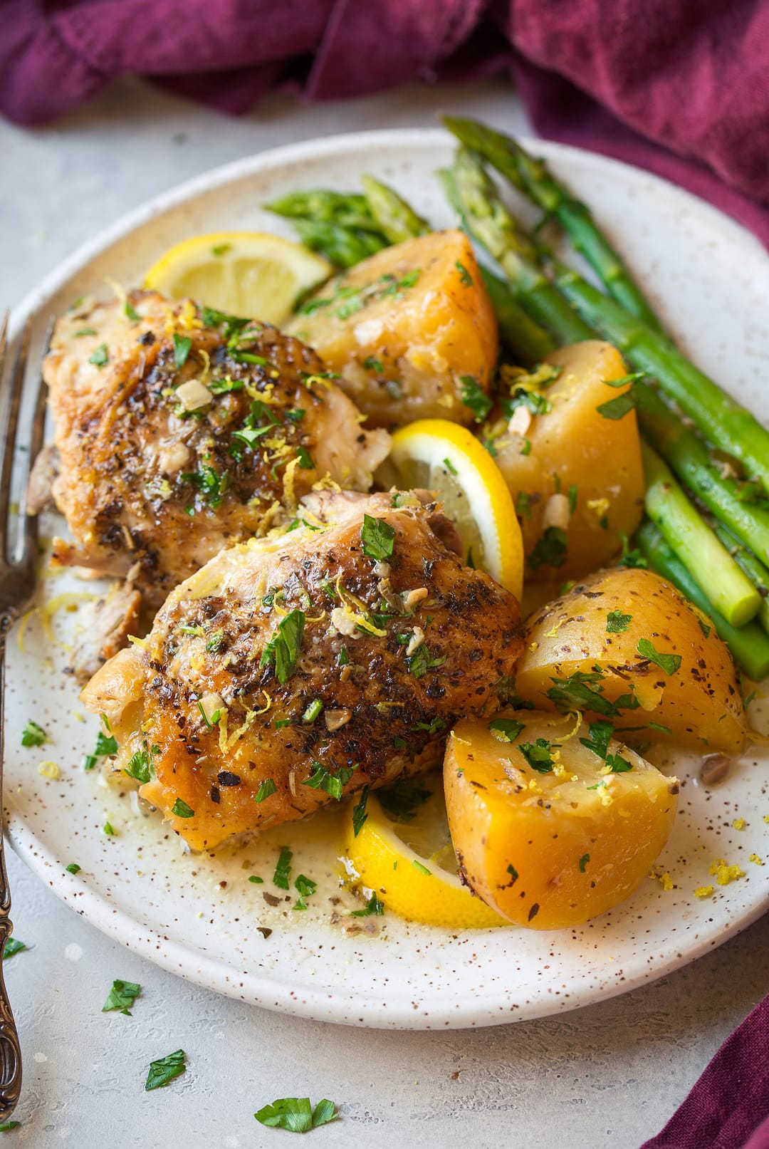 Greek Lemon Chicken and Potatoes on a plate with asparagus