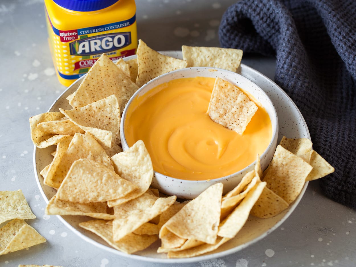 bowl of cheese dip on plate with tortilla chips