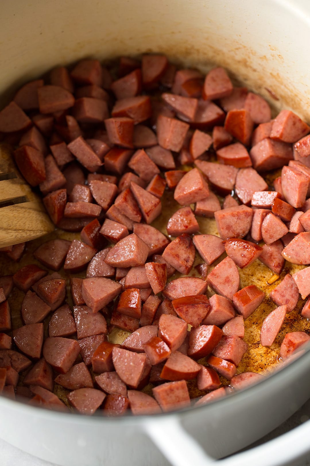 Shown here cooking turkey sausage in white enamel pot for sausage vegetable soup