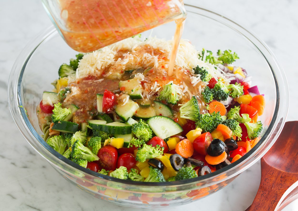 mixing pasta salad together in bowl 