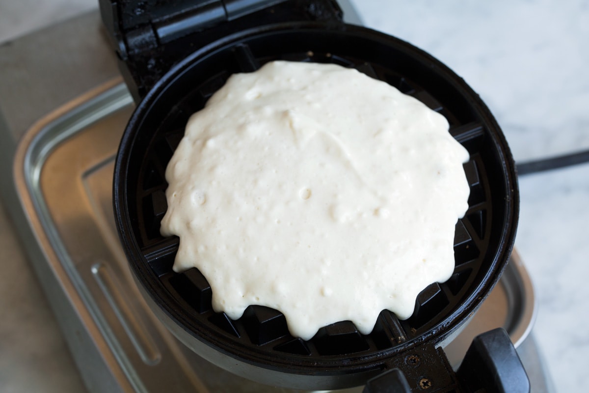 Pouring waffle batter onto Belgian waffle iron.