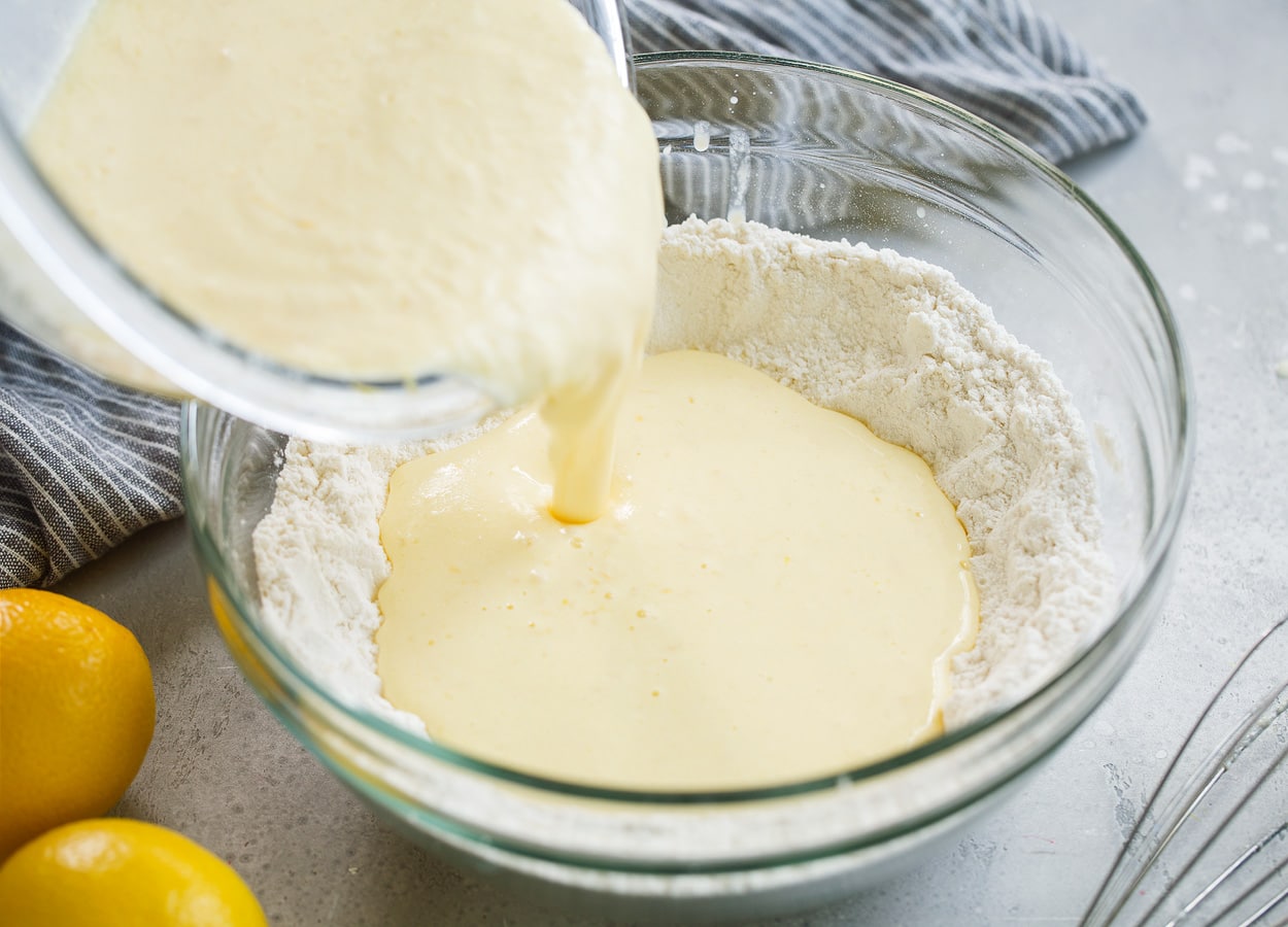 bowl of pancake flour mixture egg milk ricotta mixture being poured in