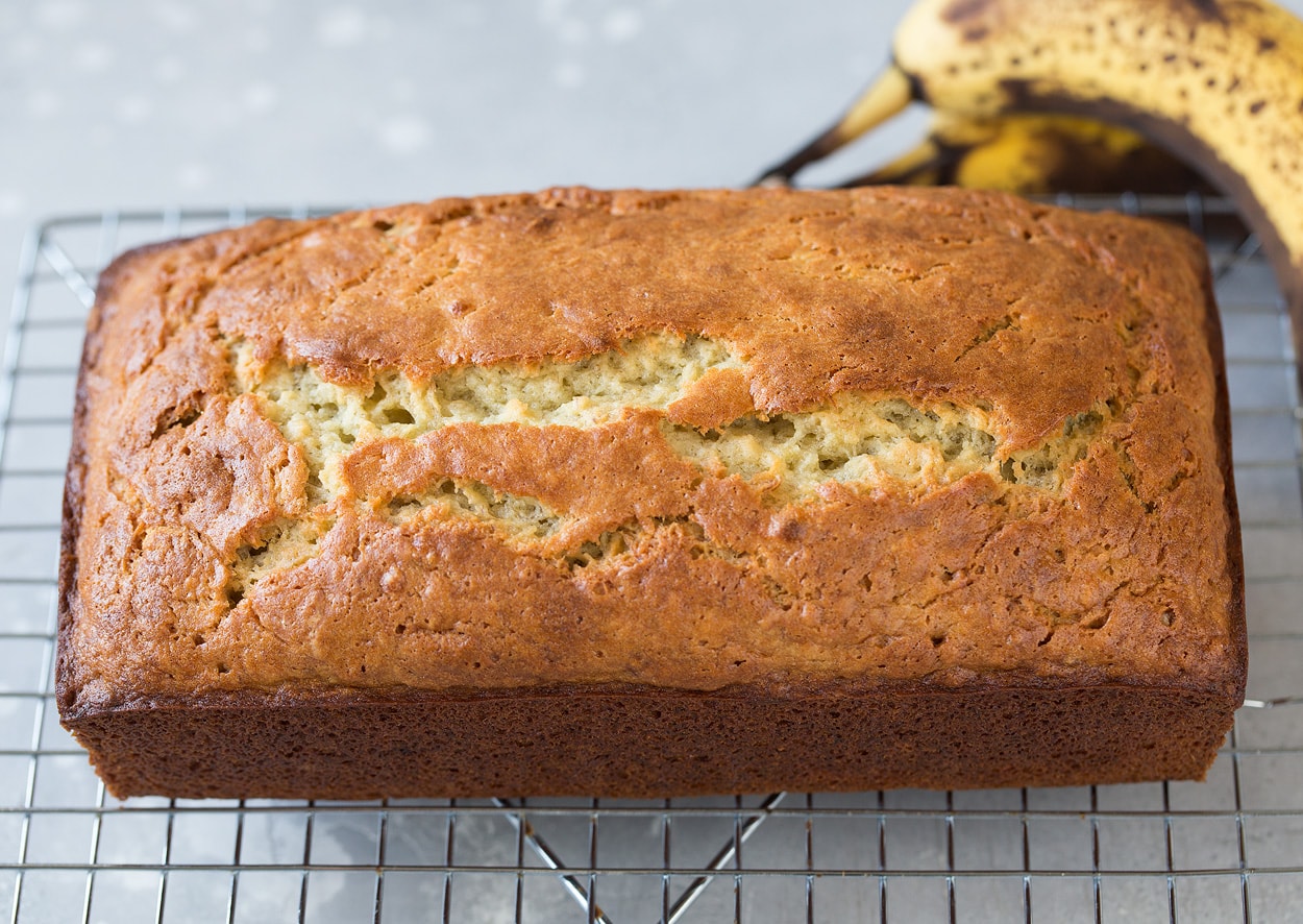 This is the best banana bread recipe! Quick and easy to make and no mixer is required. It's perfectly moist and amazingly tender and it's brimming with banana flavor. Simply put, everyone will have a hard time stopping at just one slice! #cookingclassy #banana #bread #bananabread loaf of moist banana bread on cooling rack