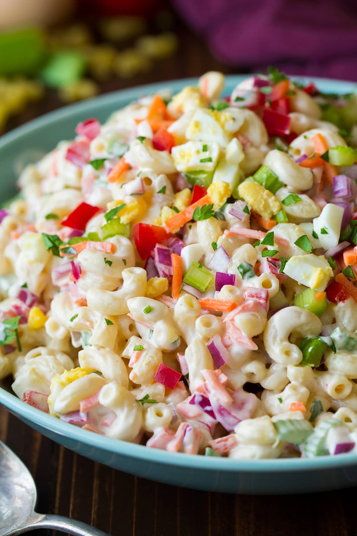 Close up side angle view of macaroni salad in a light blue bowl.