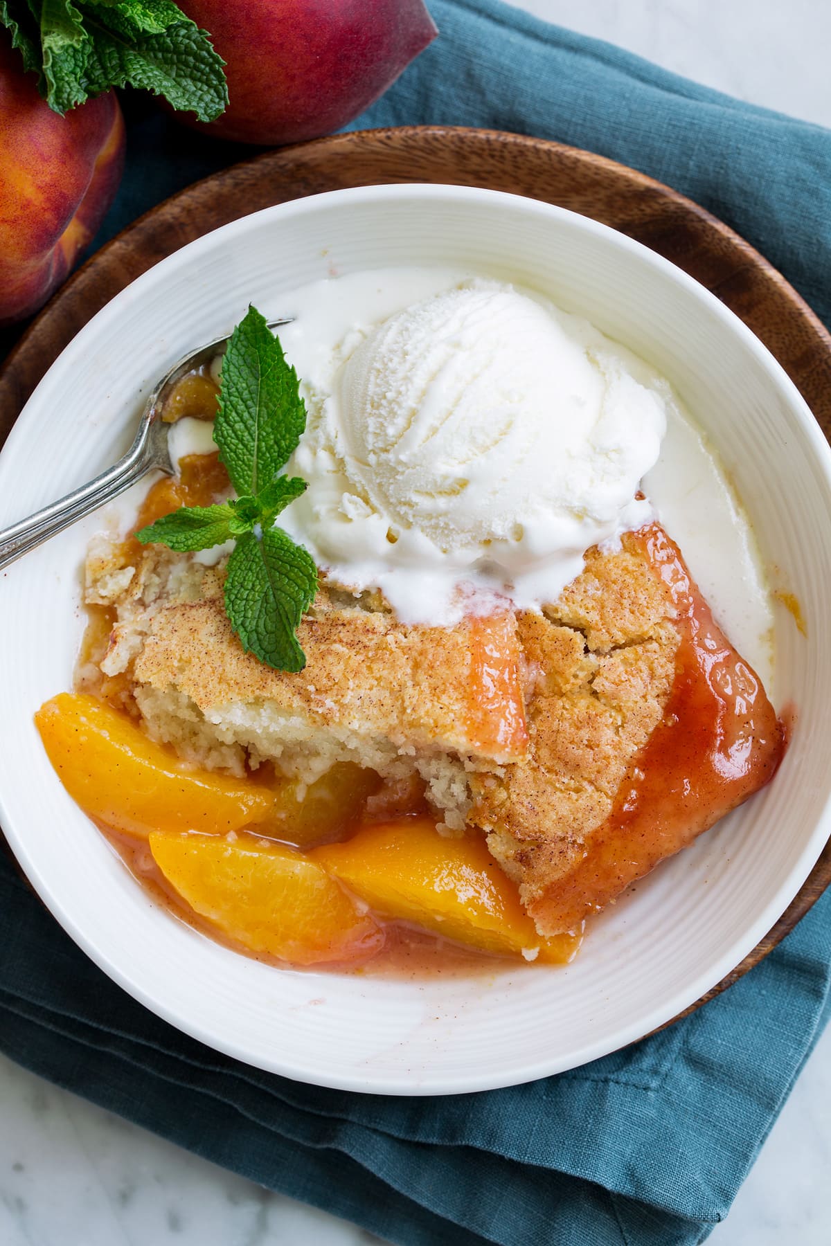 Overhead close up image of peach cobbler showing texture of filling and topping.