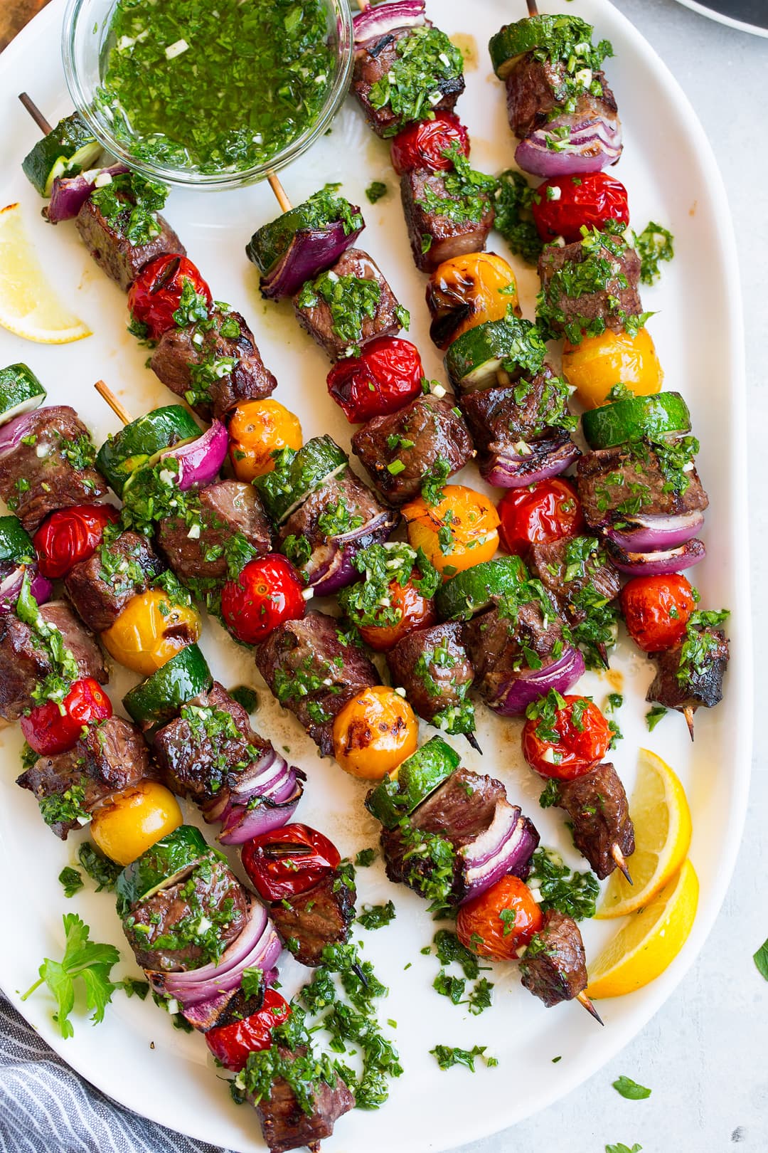 steak kebabs on platter with chimichurri