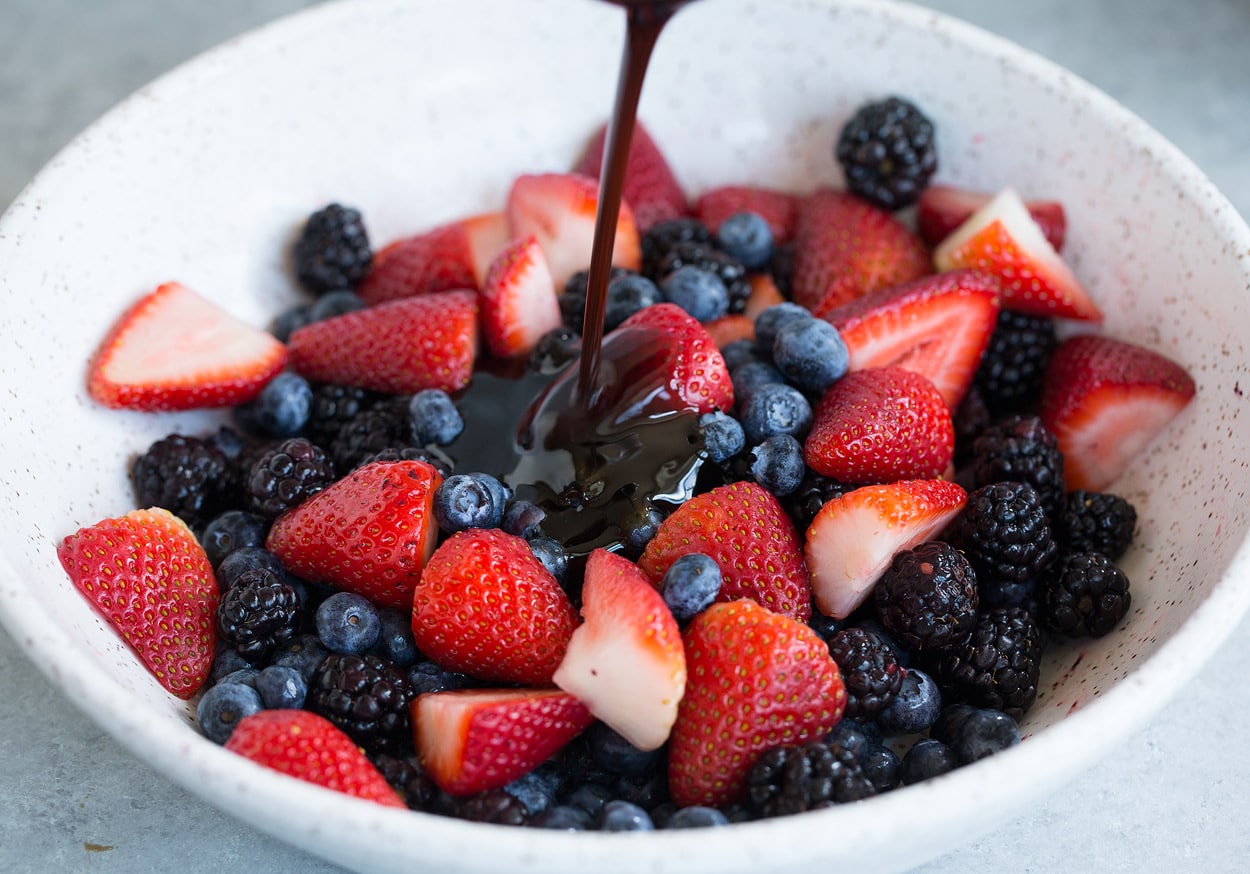 Honey Balsamic Berry Fruit Salad adding dressing