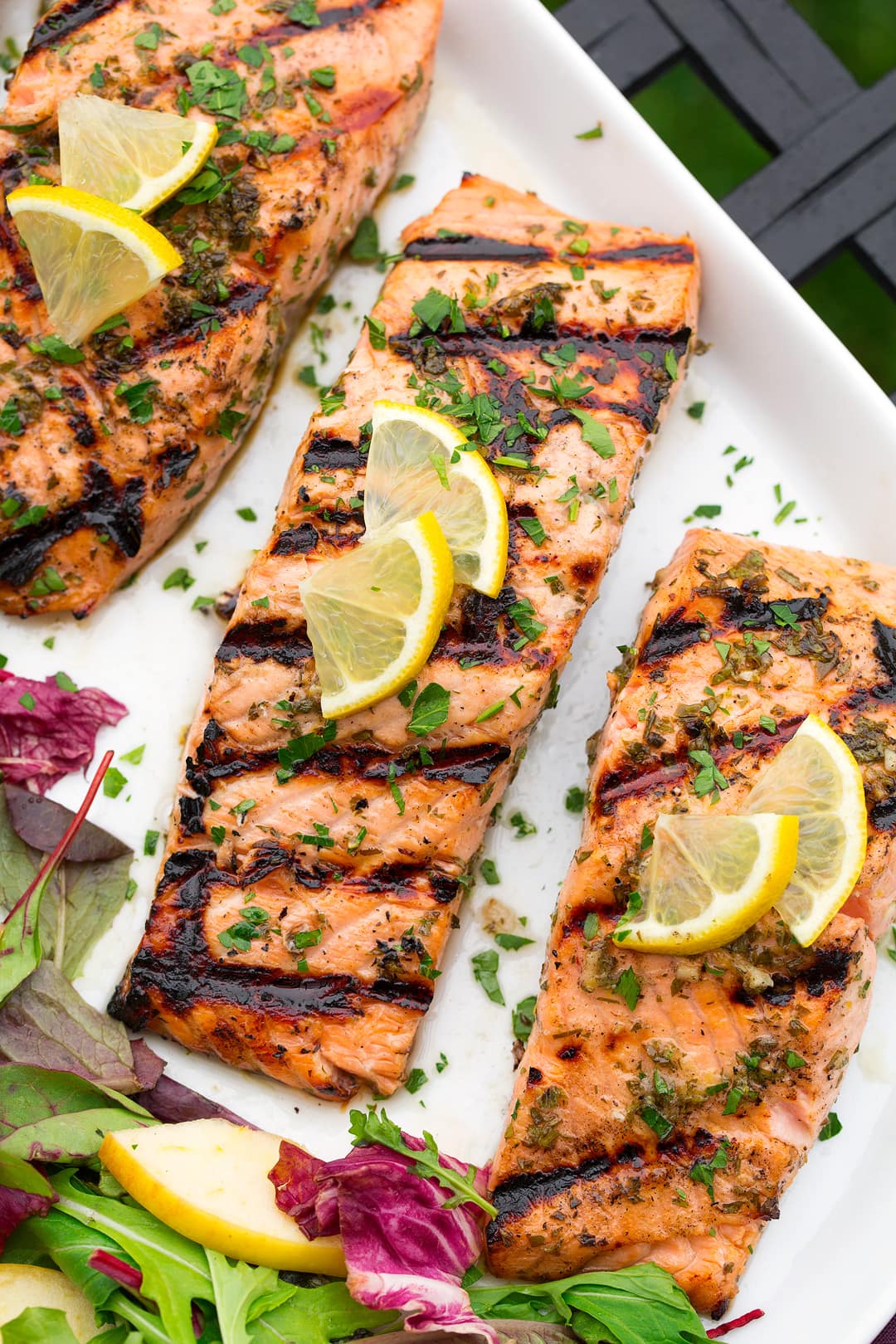 three lemon garlic salmon fillets on white plate