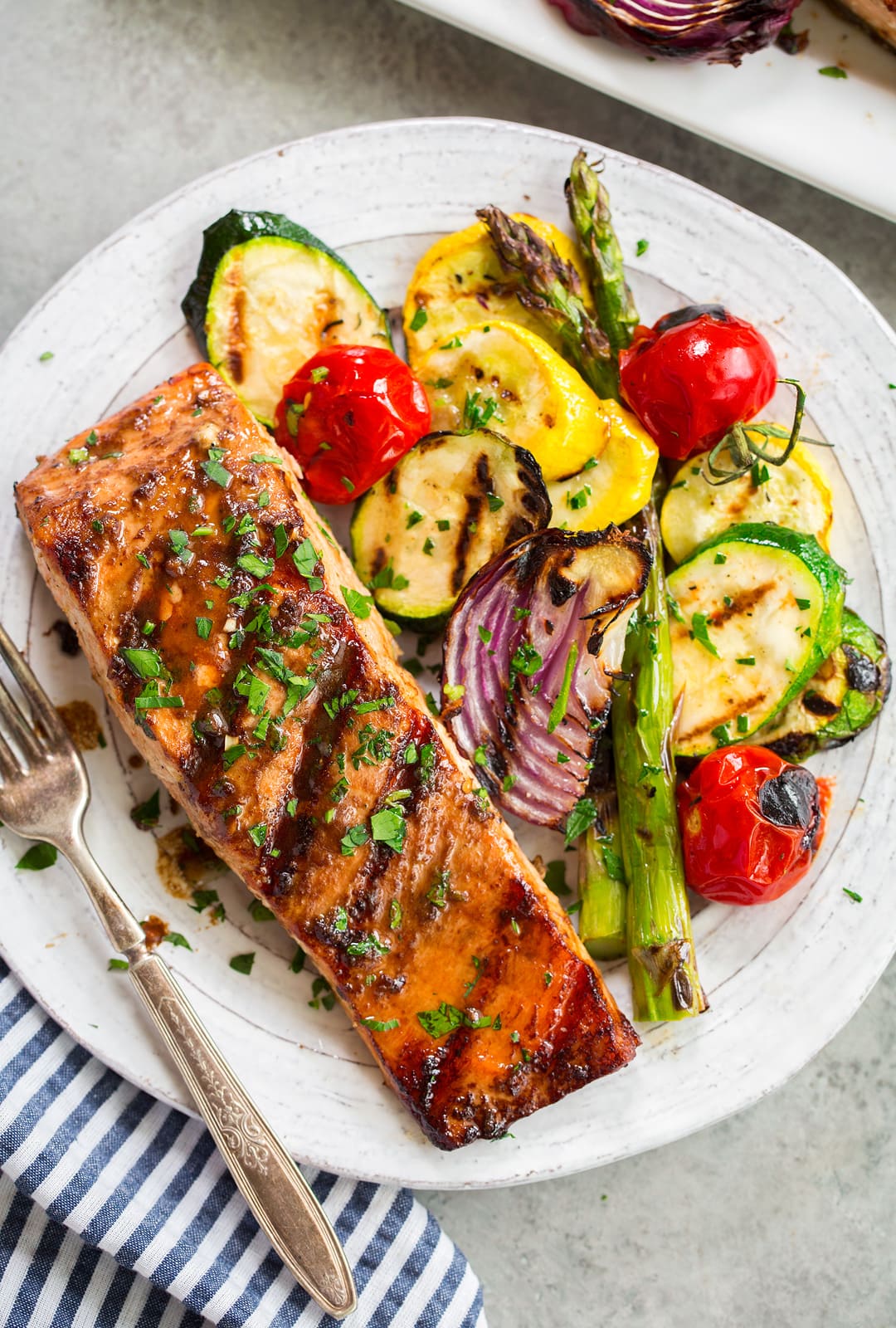 grilled salmon fillet on white plate with grilled vegetables