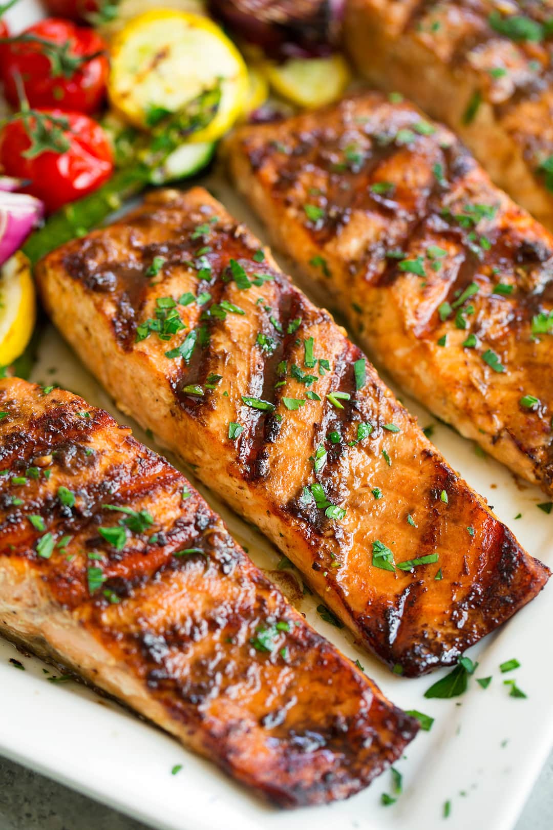 three grilled salmon fillets on white platter
