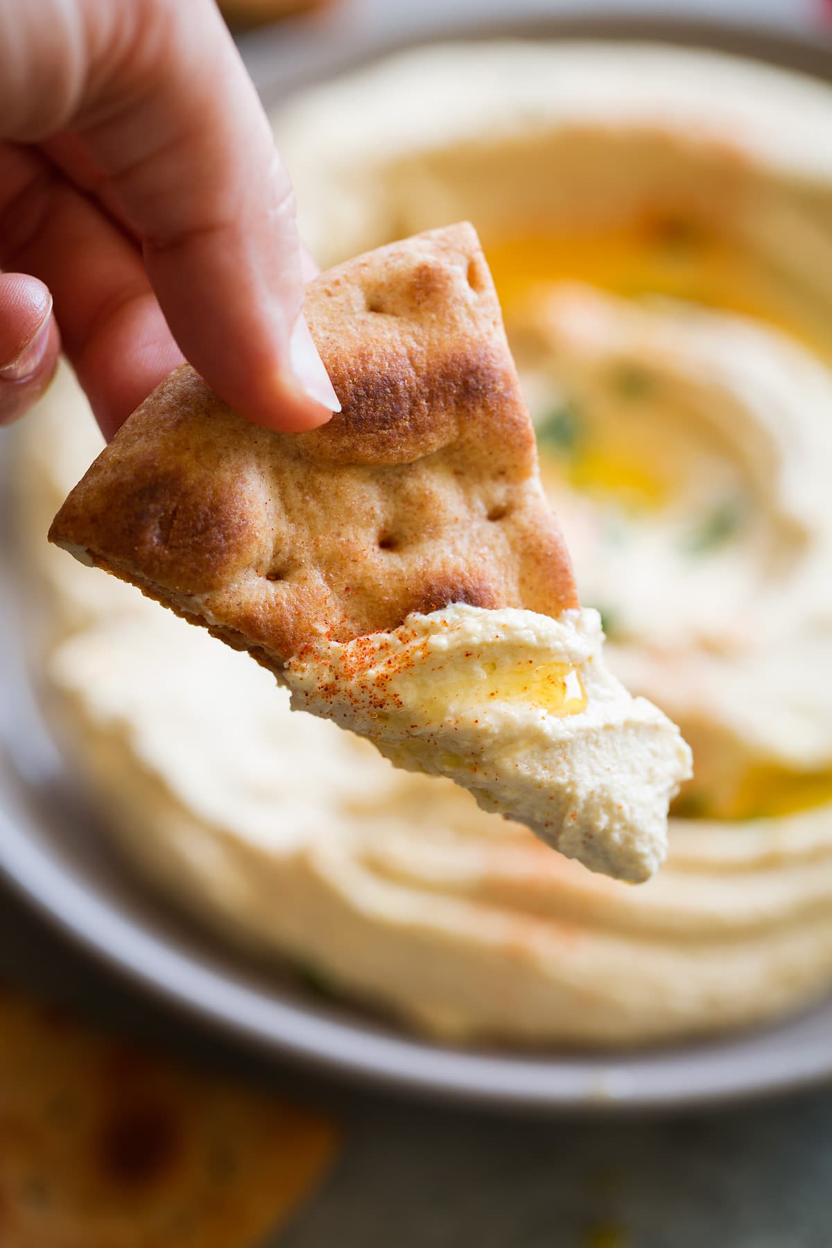 baked pita chip dunked in homemade hummus