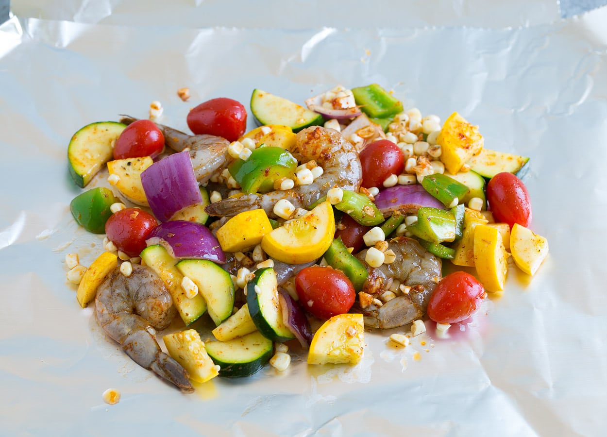 Shrimp Foil Packs laying shrimp and veggie mixture on foil