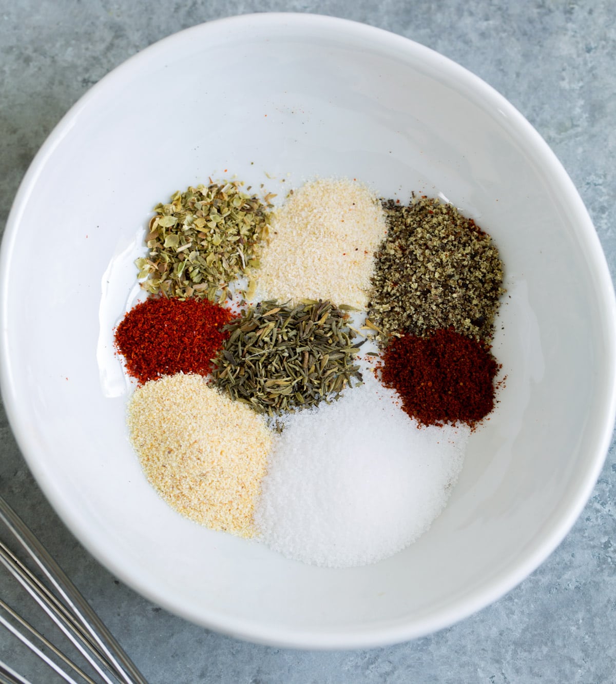 Spices in a mixing bowl to season baked chicken.