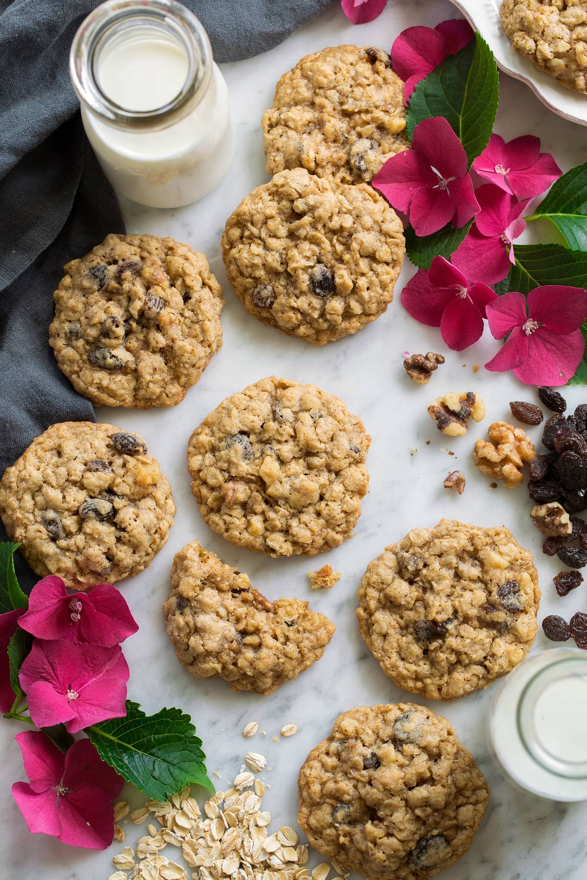 Oatmeal Raisin Cookies scattered over a marble surface, decorated with flowers.