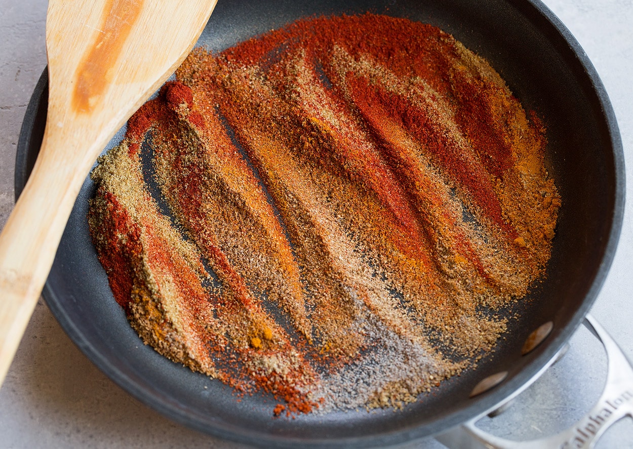 Sautéing spices in a non-stick skillet for Tandoori Chicken.
