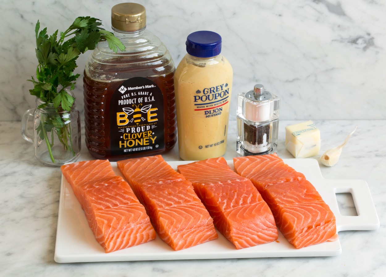 Ingredients for baked salmon shown here. Salmon fillets honey dijon mustard garlic salt pepper parsley.