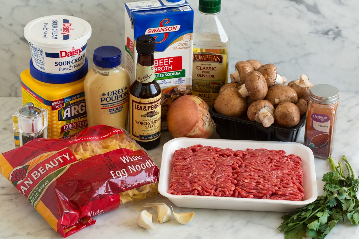 Beef Stroganoff ingredients shown here. Olive oil, mushrooms, yellow onion, garlic, lean ground beef, paprika, beef broth, dijon mustard, Worcestershire, dry egg noodles, cornstarch, sour cream