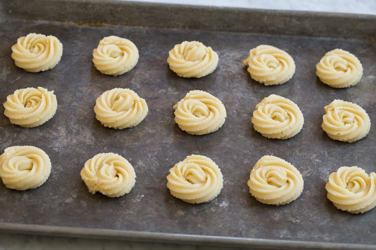 Butter cookies before baking on a baking sheet.