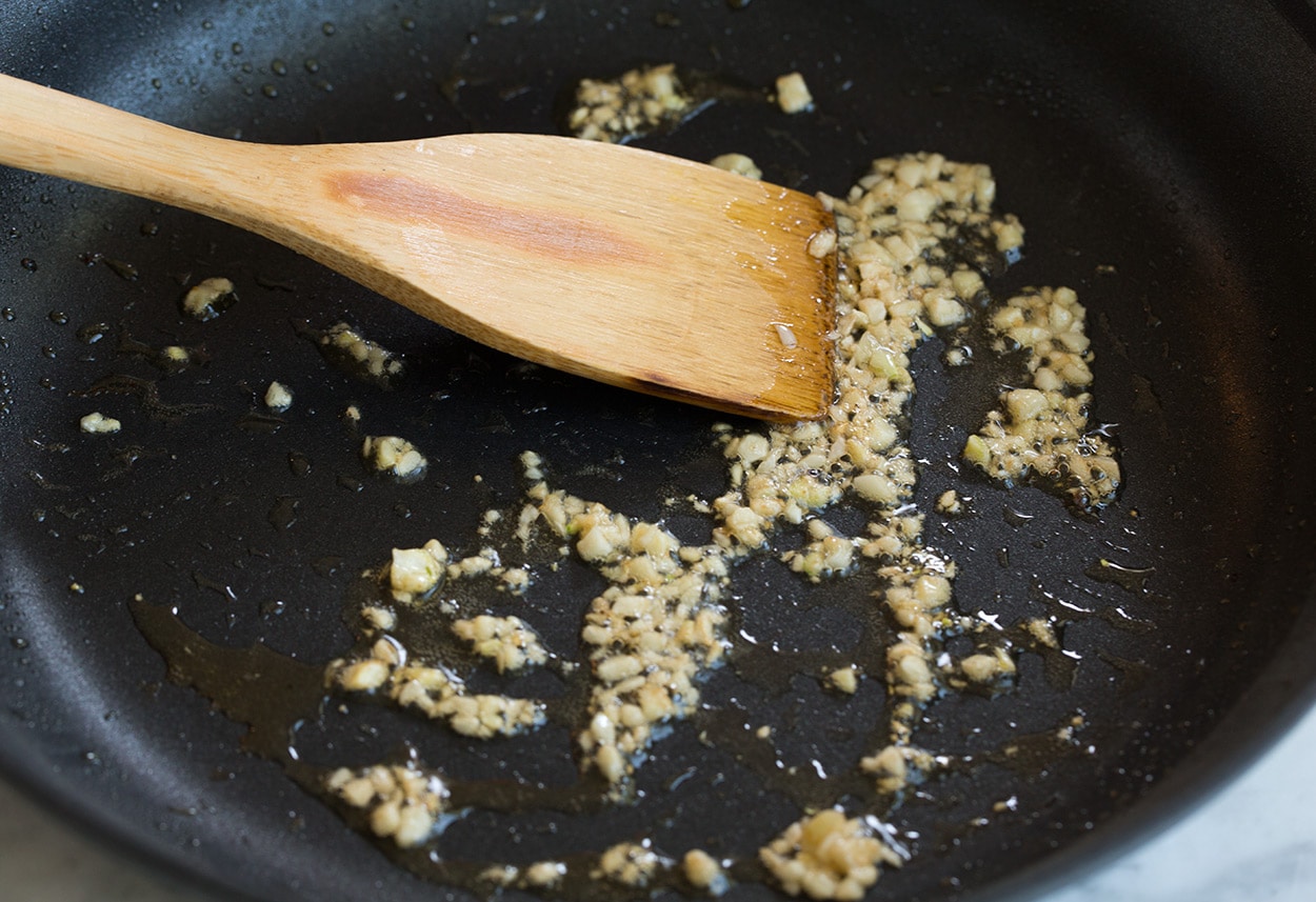 Making pan seared salmon sauteeing garlic.