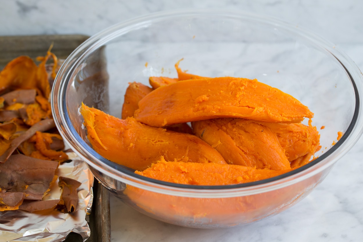 Sweet potatoes in a large glass mixing bowl to make sweet potato casserole.