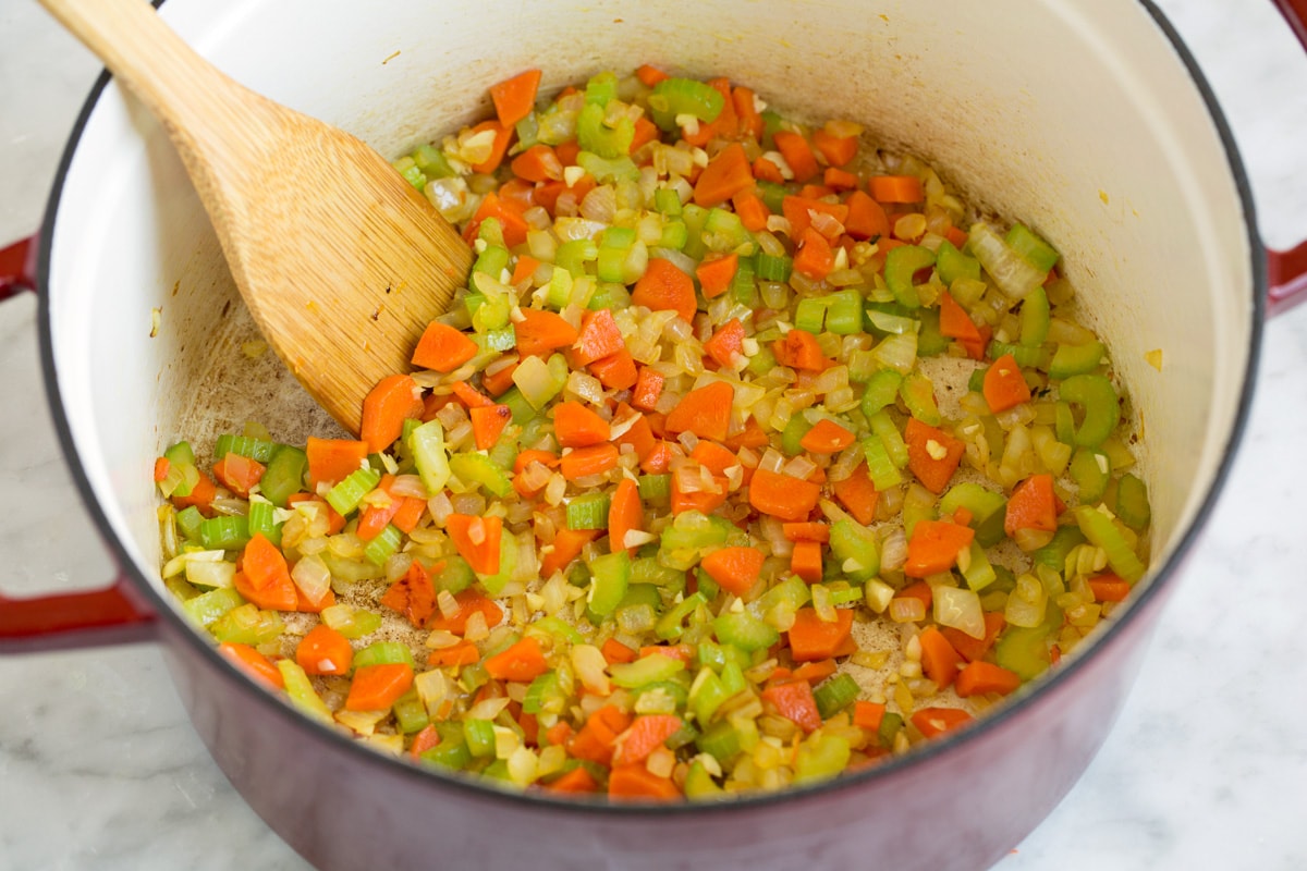 Showing how to make chicken gnocchi soup. Starting here by sauteeing carrots, onions, and celery in a large pot. 