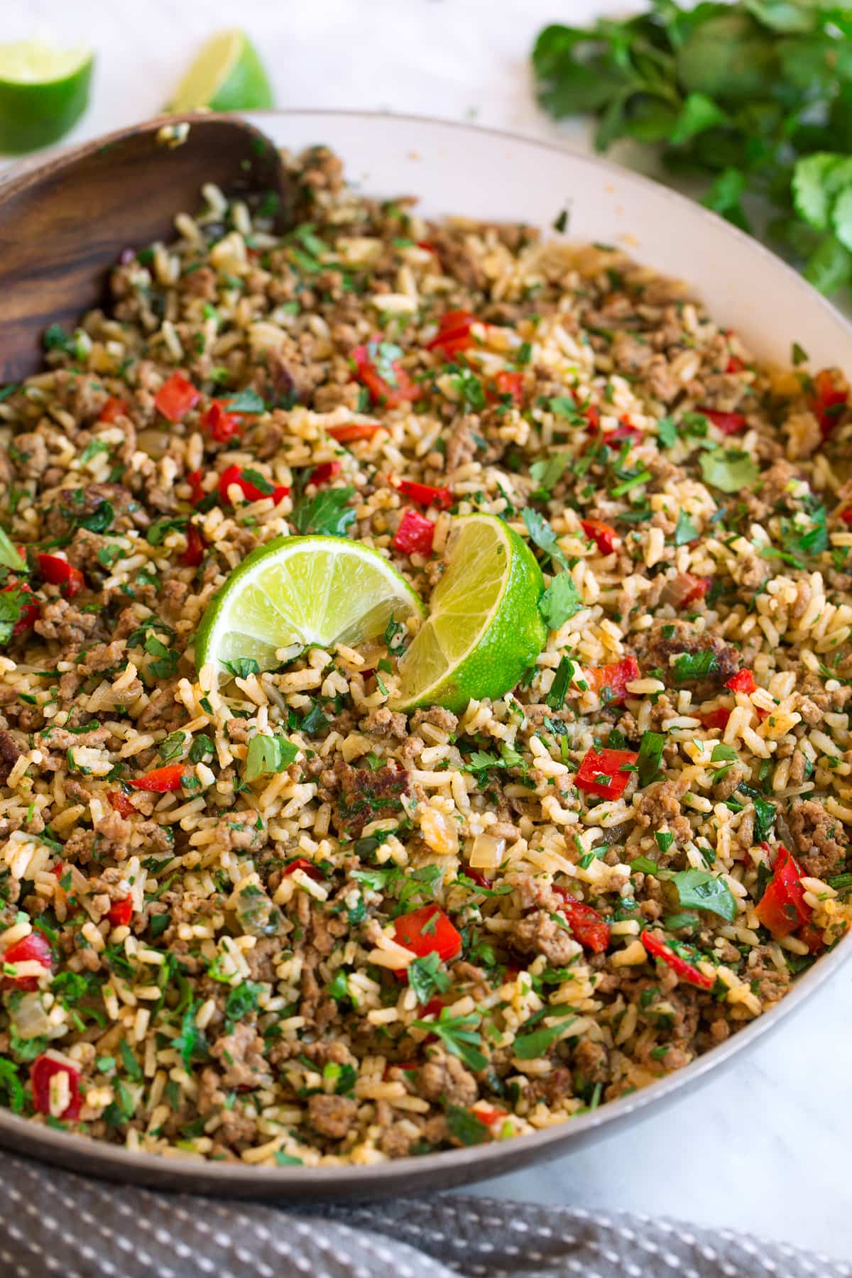 Chimichurri Beef and Rice in skillet after completed cooking. Garnished with fresh lime wedges.