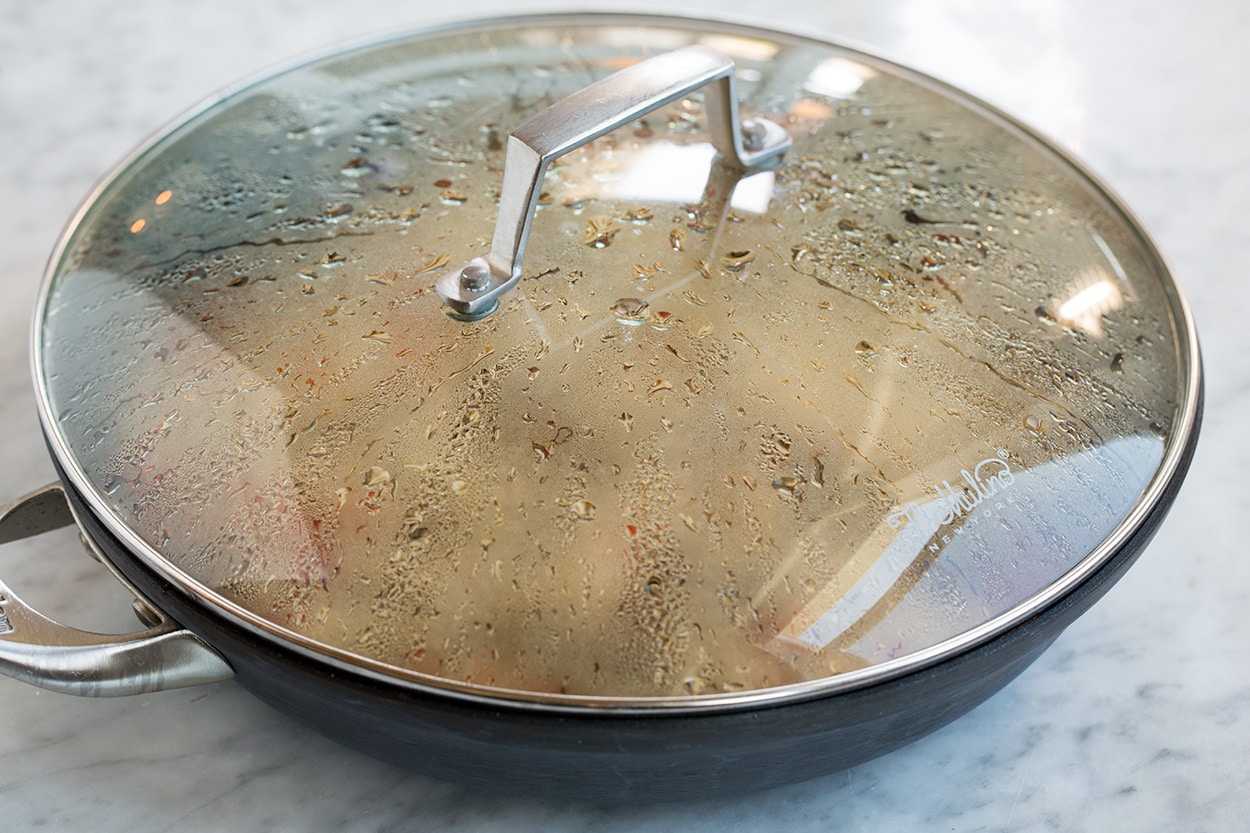 Chimichurri Beef and Rice resting in covered skillet on countertop off heat.
