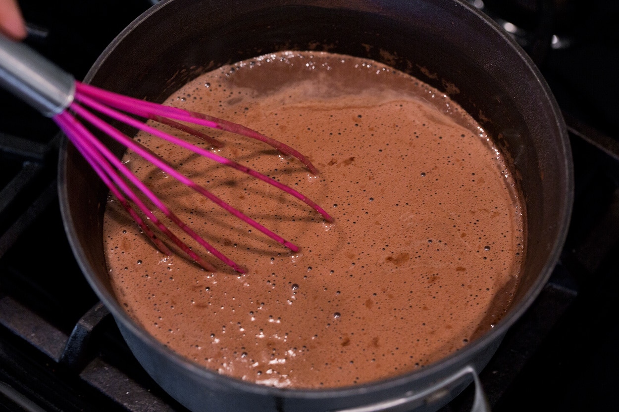 Hot Chocolate shown here cooking in a saucepan over a stovetop.