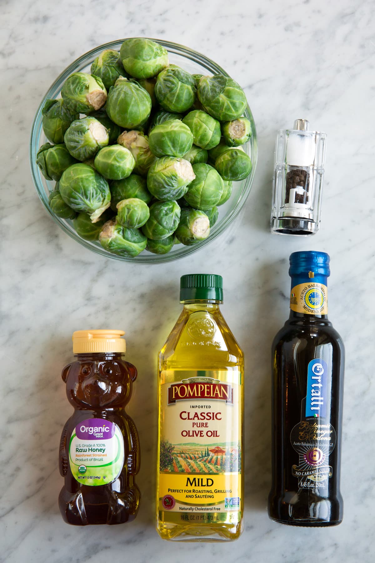Roasted Brussels Sprouts with Balsamic and Honey ingredients needed shown here on a white marble surface