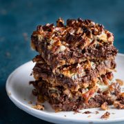 Stack of seven layer magic bars on a dessert plate.