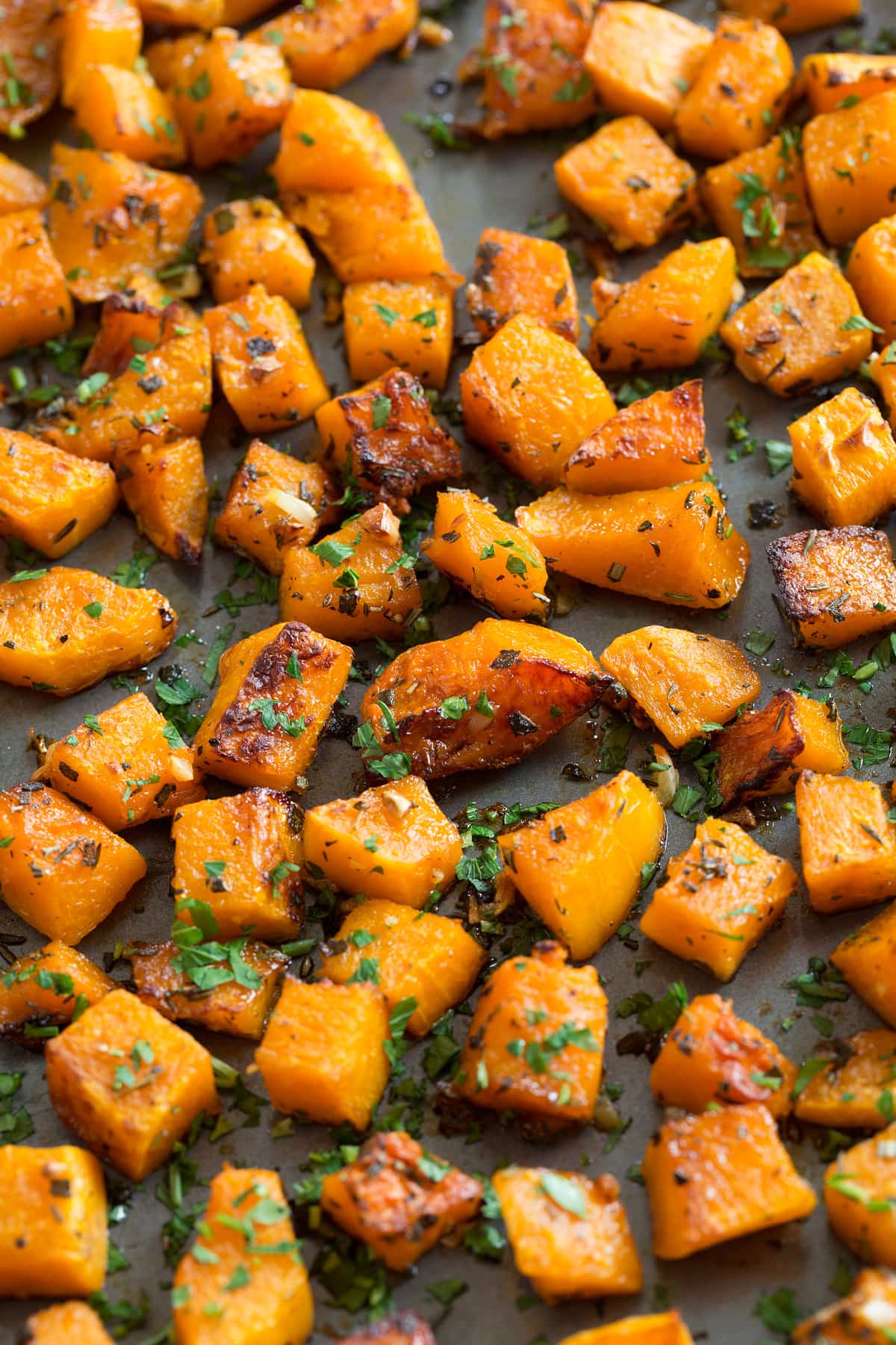 Roasted Cubed Butternut Squash on a dark baking sheet.
