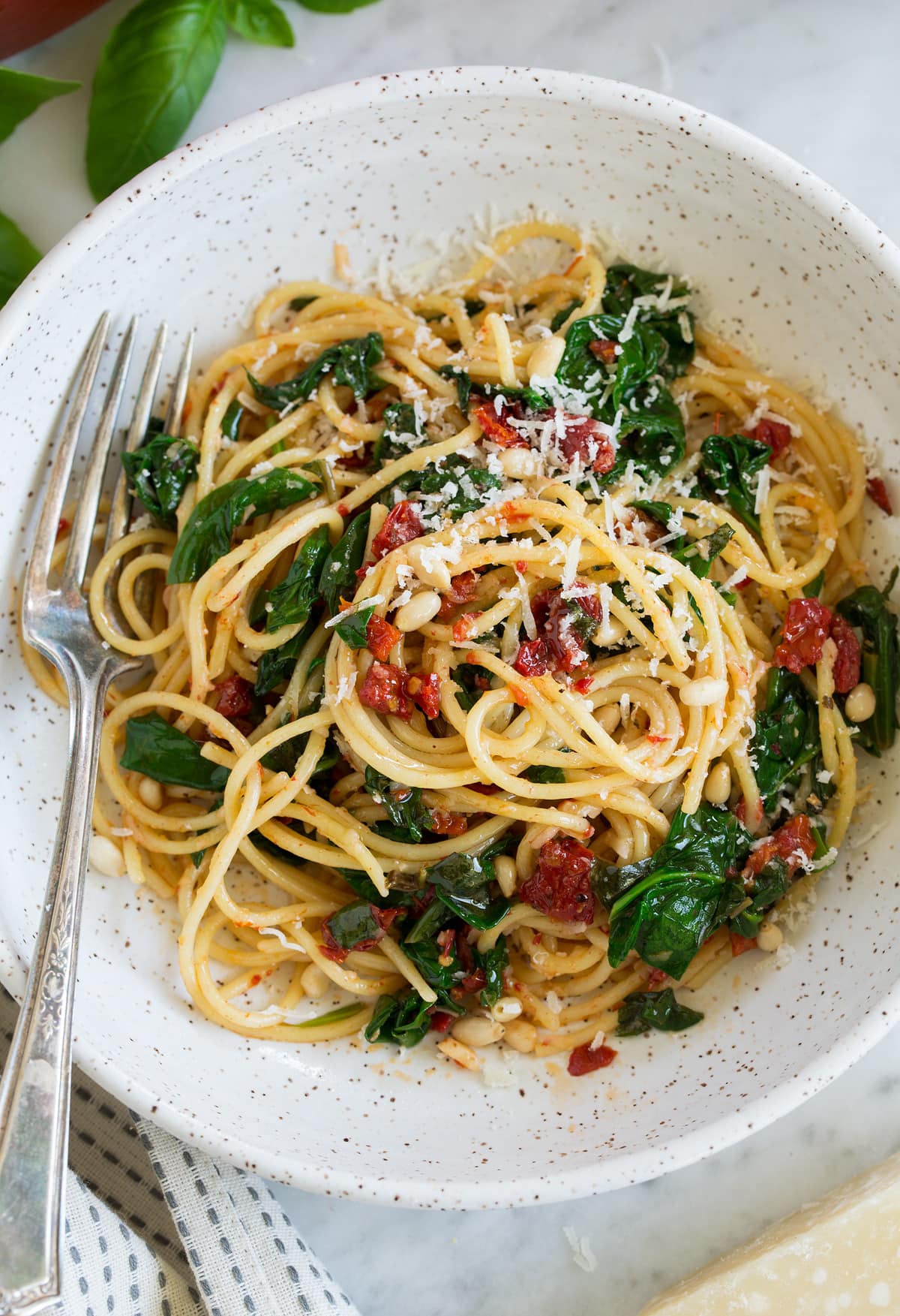 sun dried tomato pasta with fork in white bowl