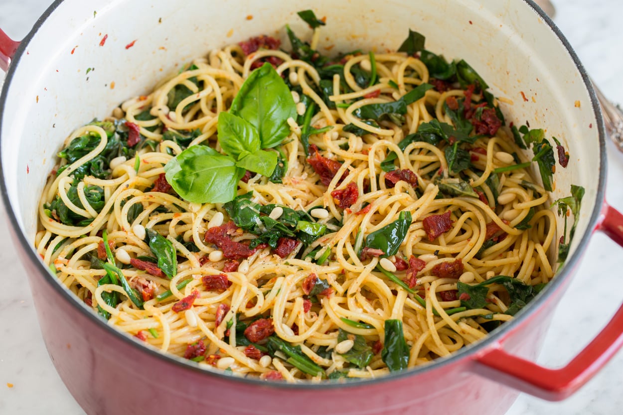sun dried tomato pasta garnished with fresh basil in large pot
