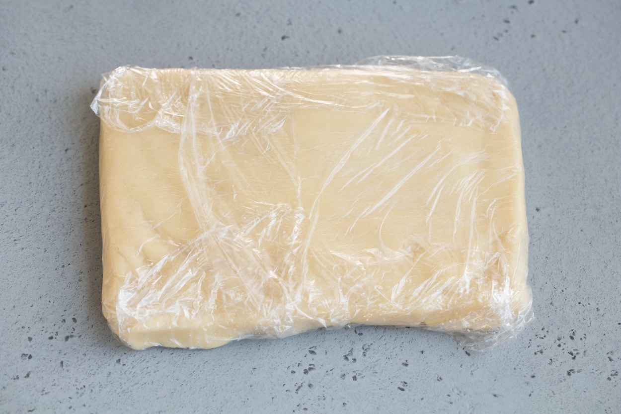 Stained glass cookie dough in rectangle shape in plastic wrap.