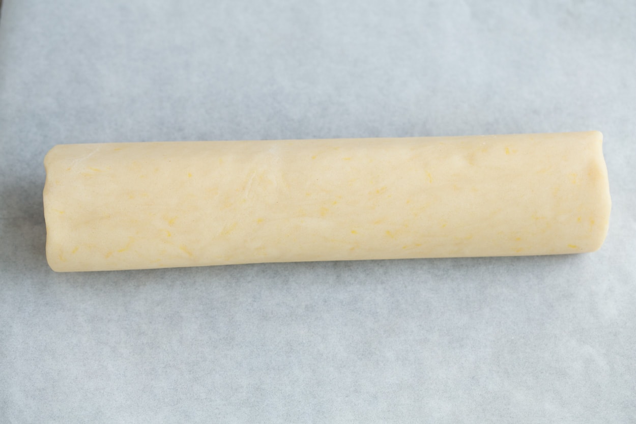Showing how to make lemon shortbread cookies. Rolling dough into a log.