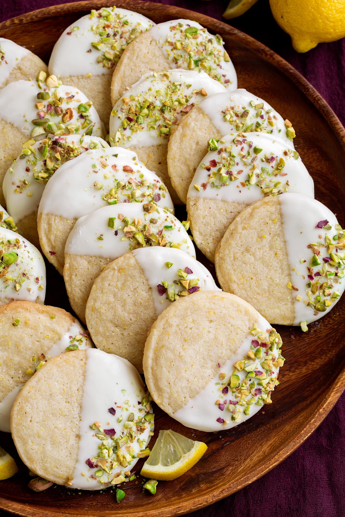 Shortbread cookies on a wooden serving plate. Flavored with lemon, white chocolate and pistachios.