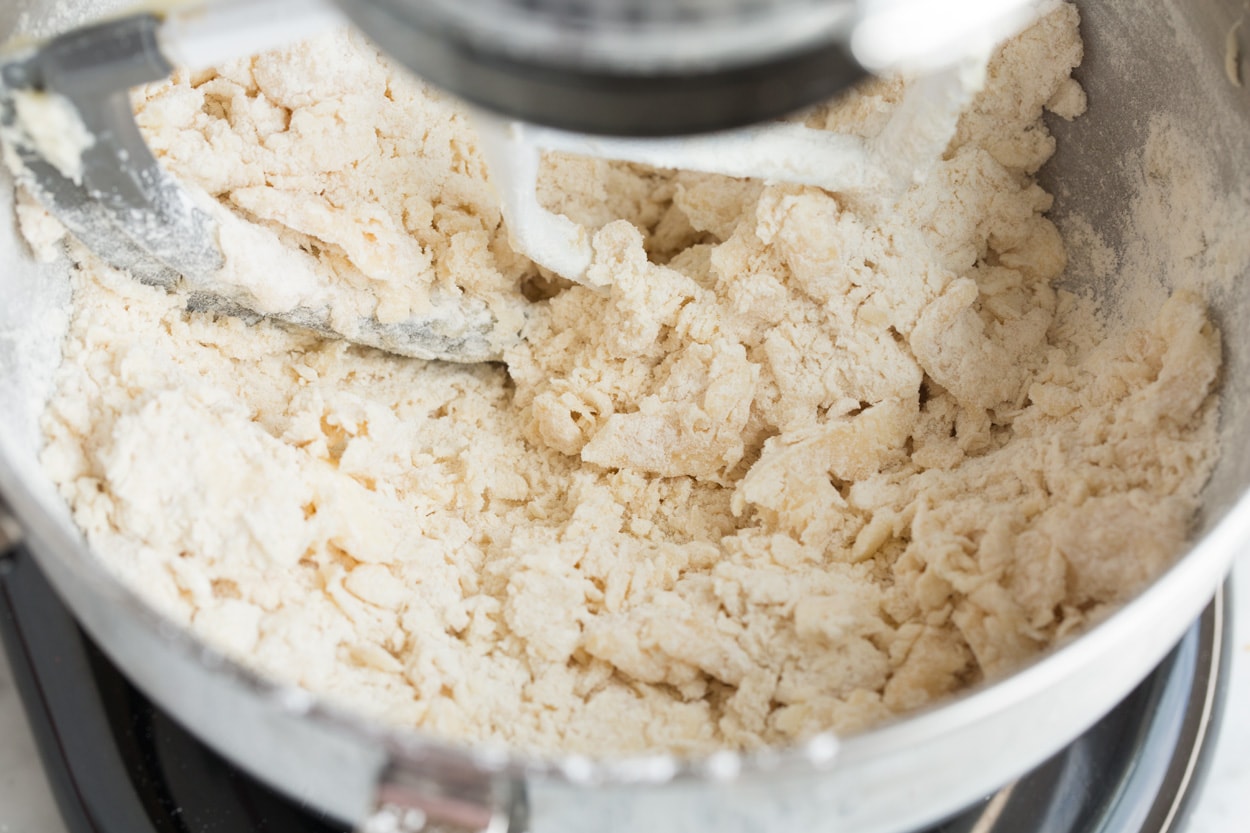 Sandy flour mixture coming together in mixing bowl. For Mexican Wedding Cookies.