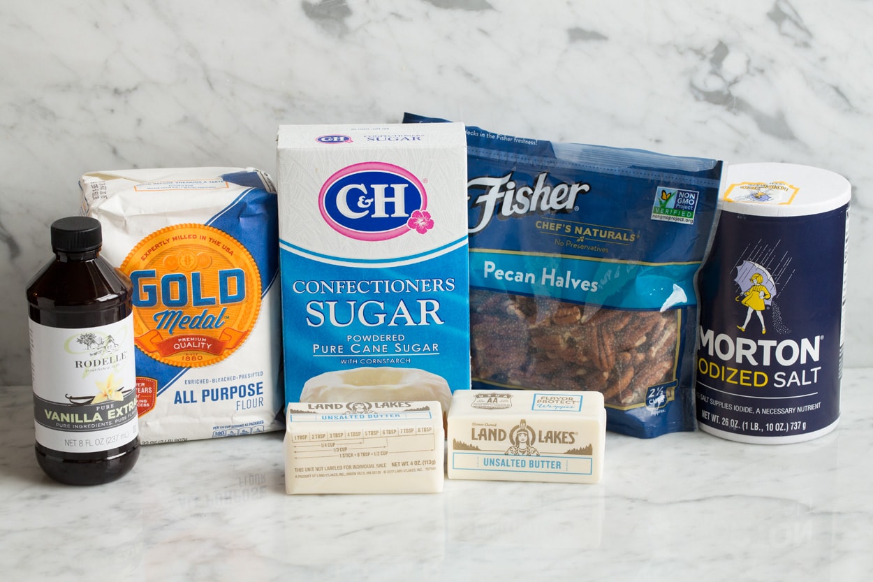 Mexican Wedding Cookies ingredients shown. Flour, butter, sugar, salt, vanilla, pecans, powdered sugar