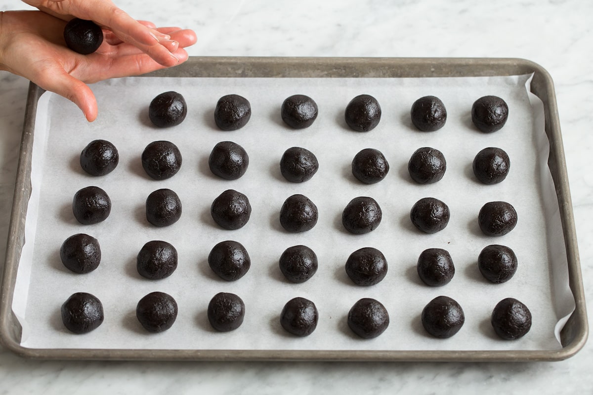 Uniform rolled oreo balls on a baking sheet.