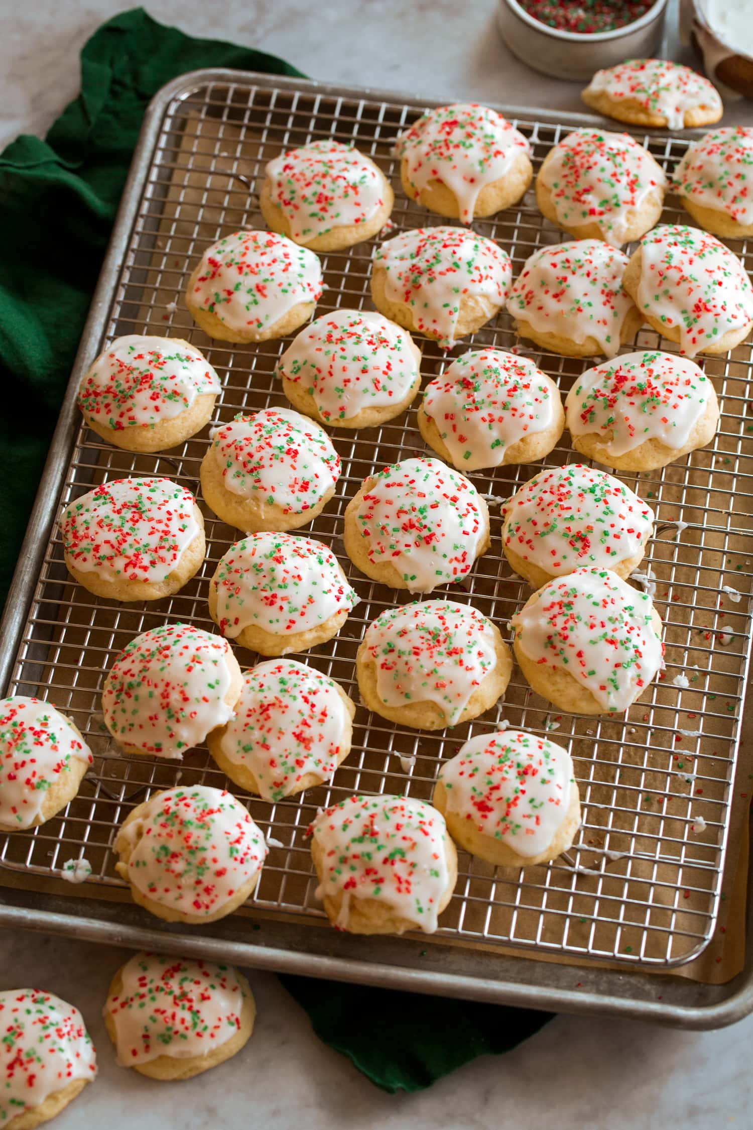 Ricotta Cookies Ricotta cookies with glaze on a wire cooling rack over a baking sheet.